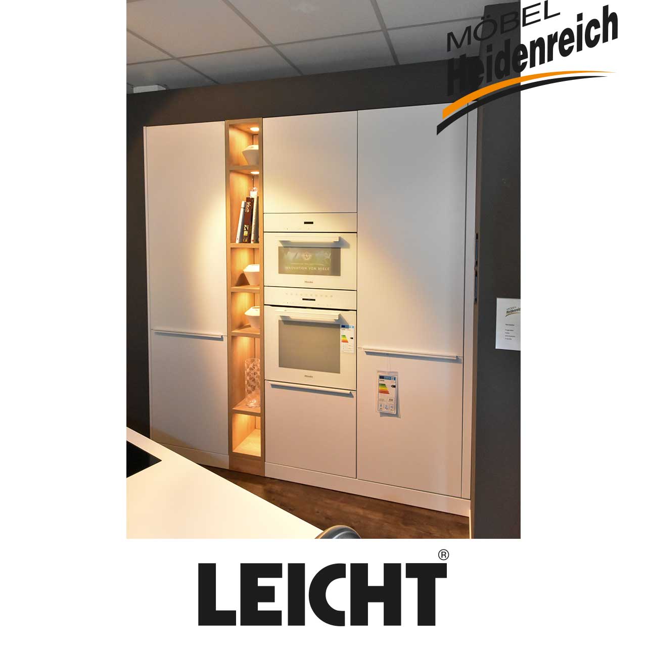 Helle Küchenzeile mit eingebauten Großelektrogeräten und beleuchtetem Regal in Holzoptik als Zwischenbauteil.