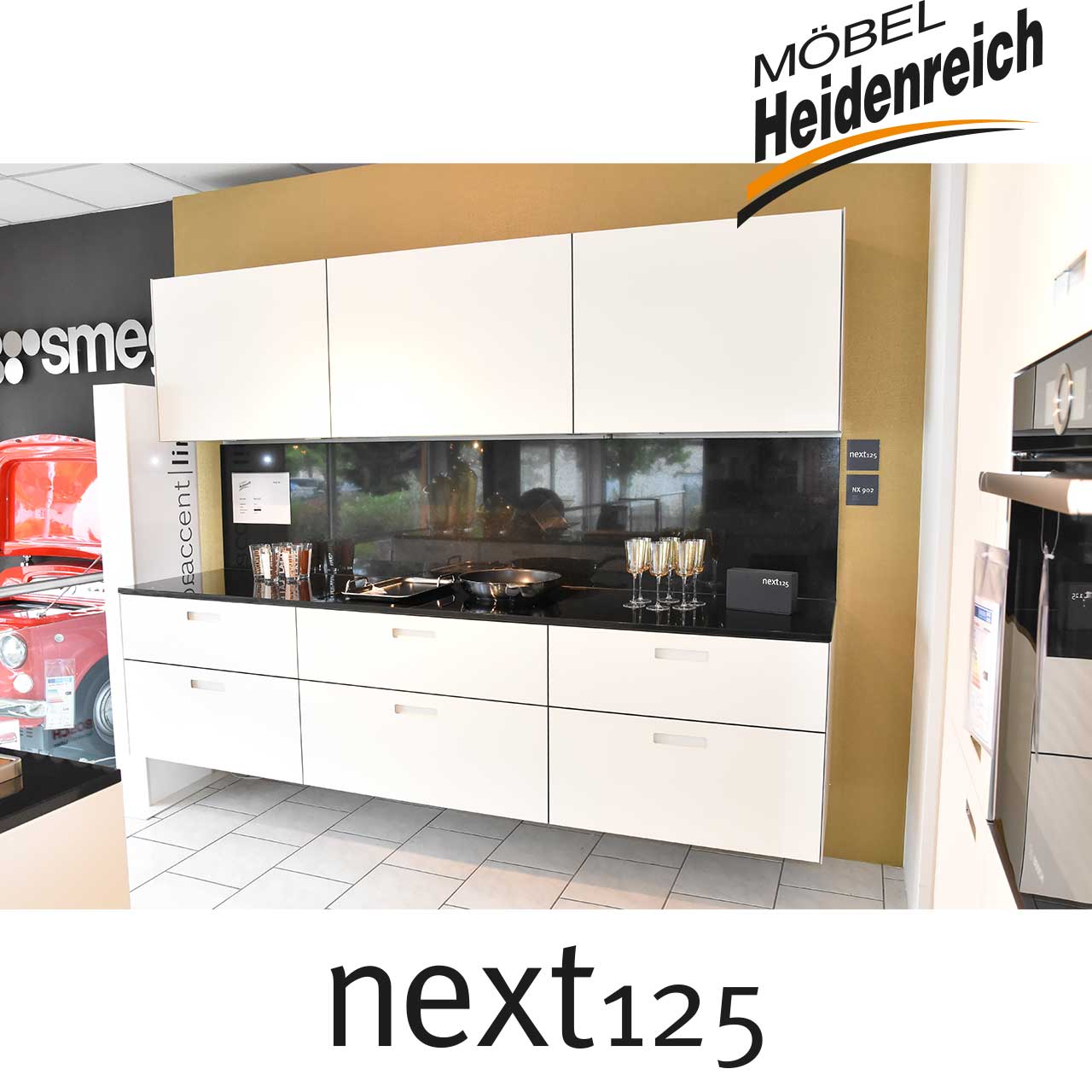 Weiße Küchenzeile mit schwarzer Abdeckplatte und Rückwand.