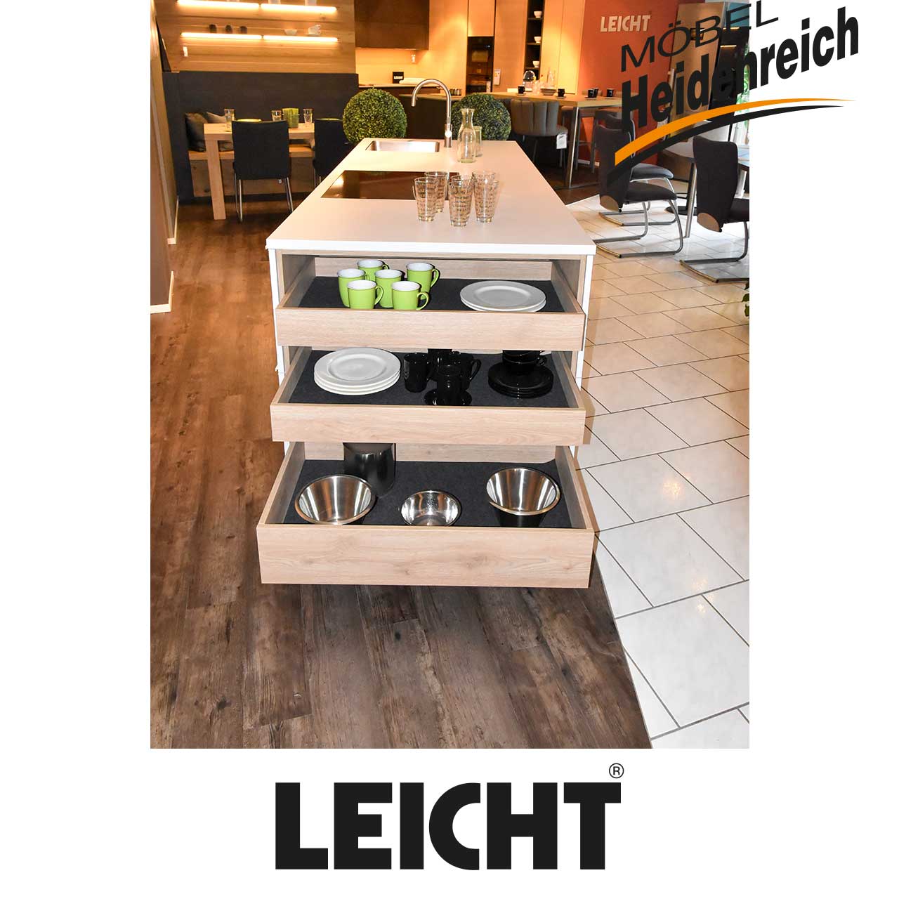 Seitenansicht der Kochinsel zeigt drei Schubladen mit heller Holzfront, die ausgezogen sind.