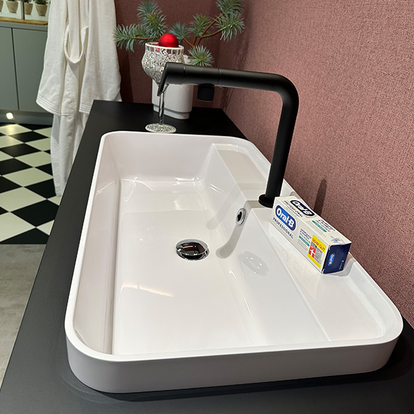 Detailaufnahme Aufsatz-Waschbecken in weiß mit schwarzer Armatur.