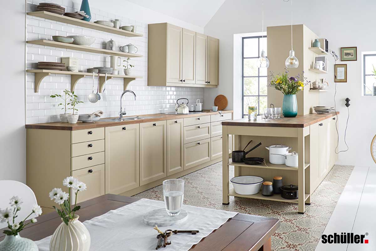 Landhausstil Küche Helle Küche im Landhausstil von Schüller mit viel Stauraum und Hängeregalen. Kassetten-Look der Fronten und verspielte Türknäufe.
