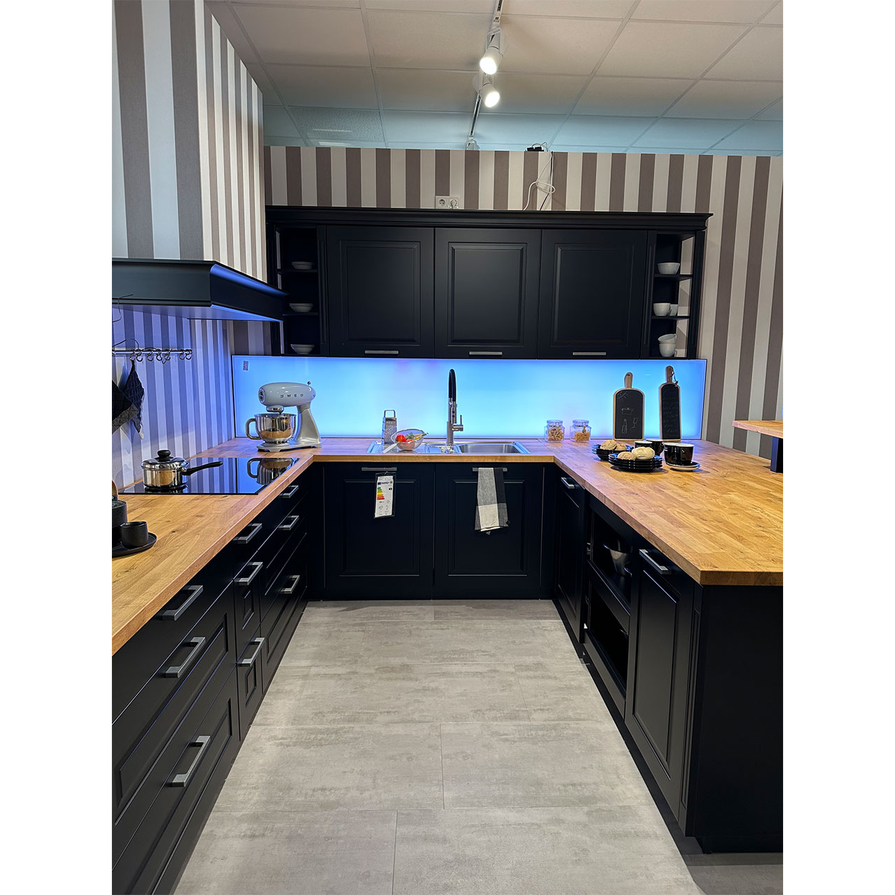 Auf der linken und rechten Seite befinden sich Unterschränke mit viel Stauraum, frontseitig die Spüle mit Oberschränken darüber.