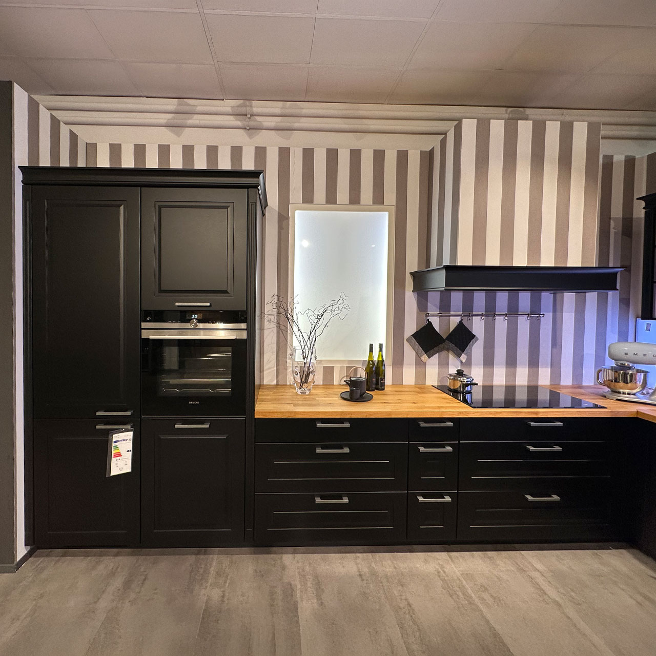 Die linke Seite der U-förmigen Küche beinhaltet links die integrierten Großelektrogeräte, daneben Unterschränke mit Schubladen, Kochfeld mit Dunstabzug.