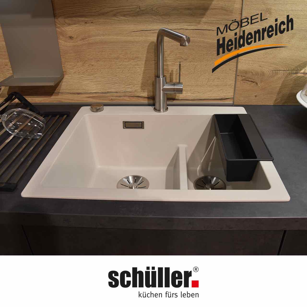 Blick auf die weiße Spüle mit Nebenfach und zweitem Ablauf. Edelstahlarmatur mit Einhandmischer.
