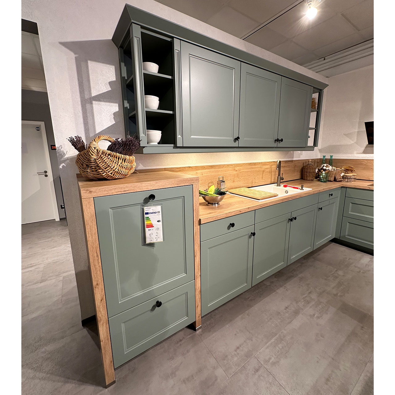 Diese Zeile bietet viel Staurau mit Ober- und Unterschränken sowie der in die Holzplatte eingebauten Keramikspüle.