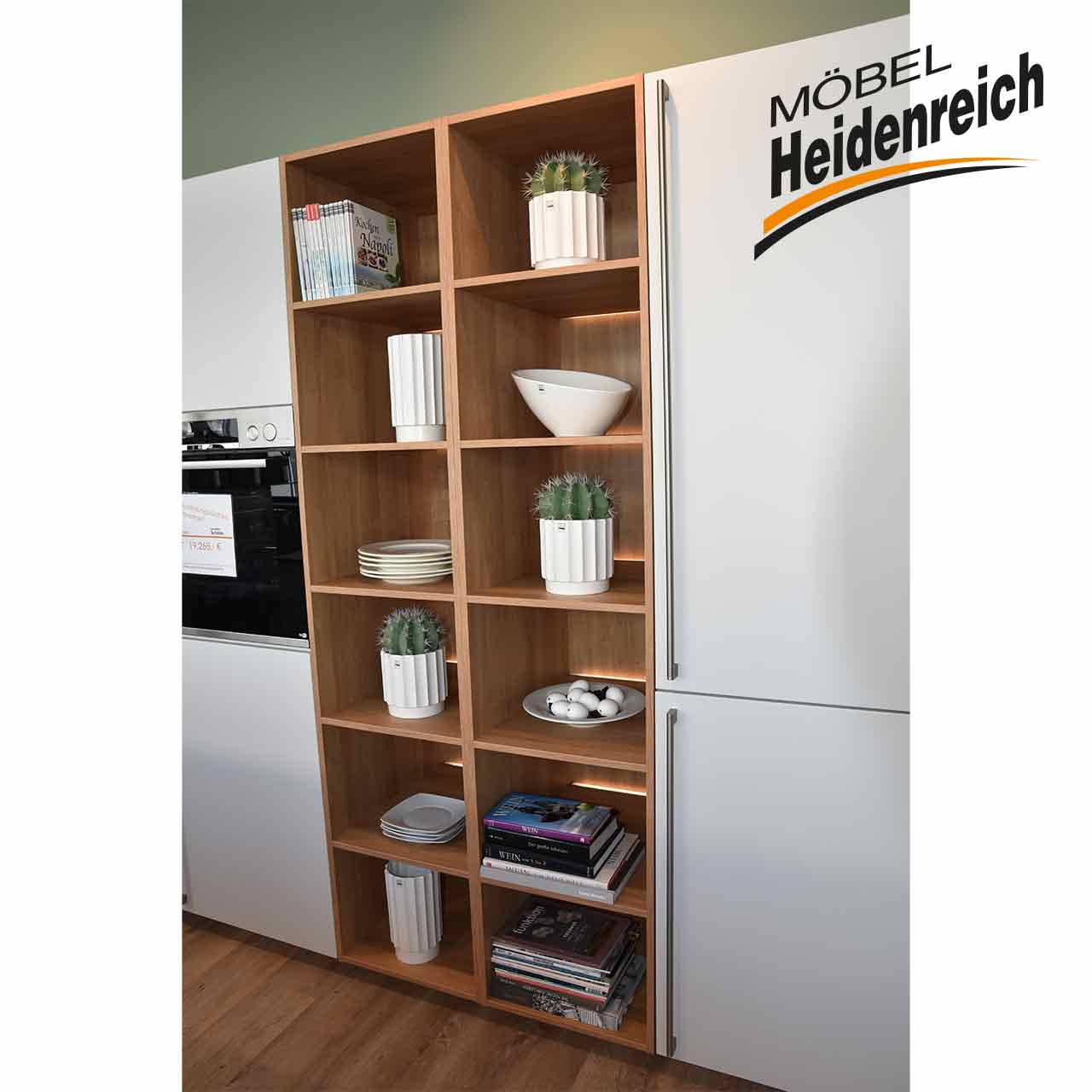 Regal aus hellem Holz mit zwölf Fächern als Zwischebau in der Küchenzeile.