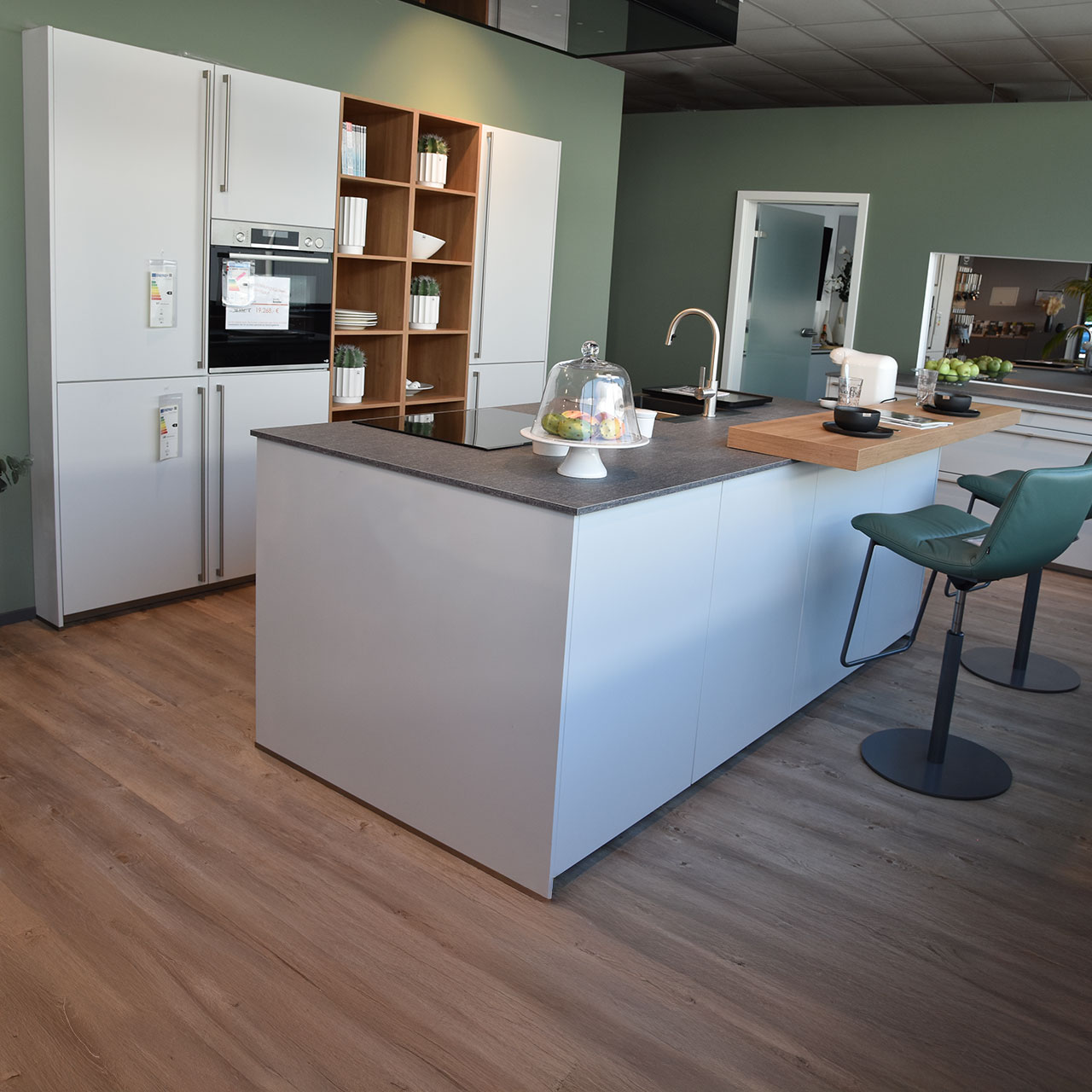 Weiße Küche mit Regaleinsätzen aus hellem Holz und Kücheninsel davor.