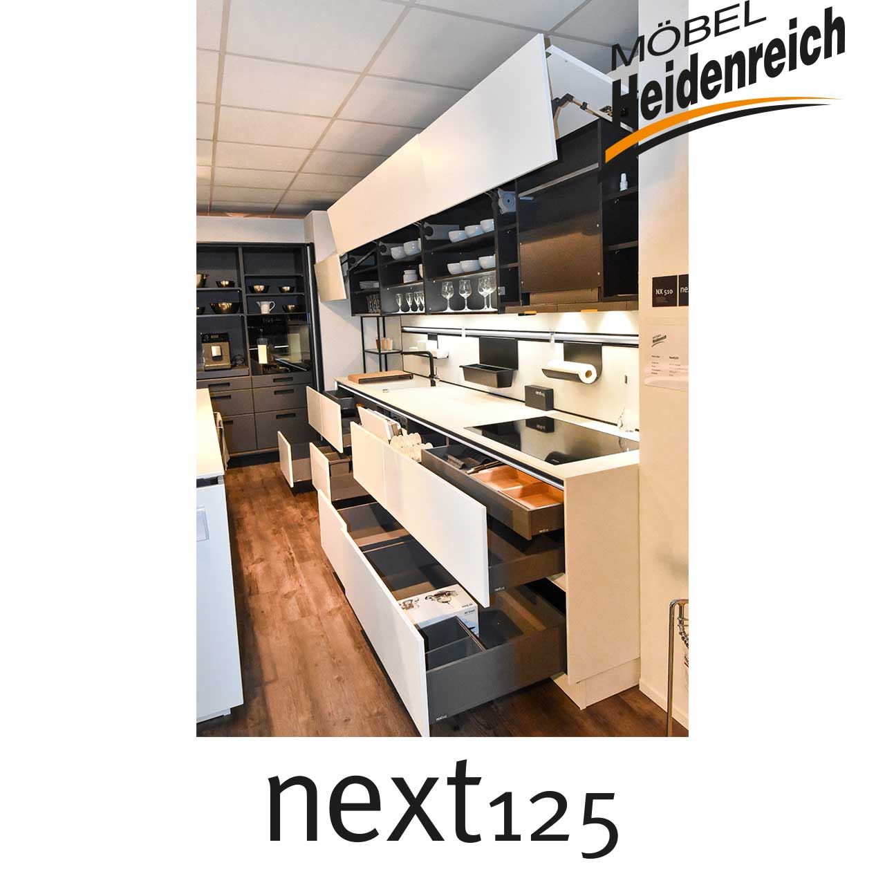 next125 Küche - Küchenzeile geöffnet Küchenzeile mit geöffneten Oberschränken und Schubladen unten.
