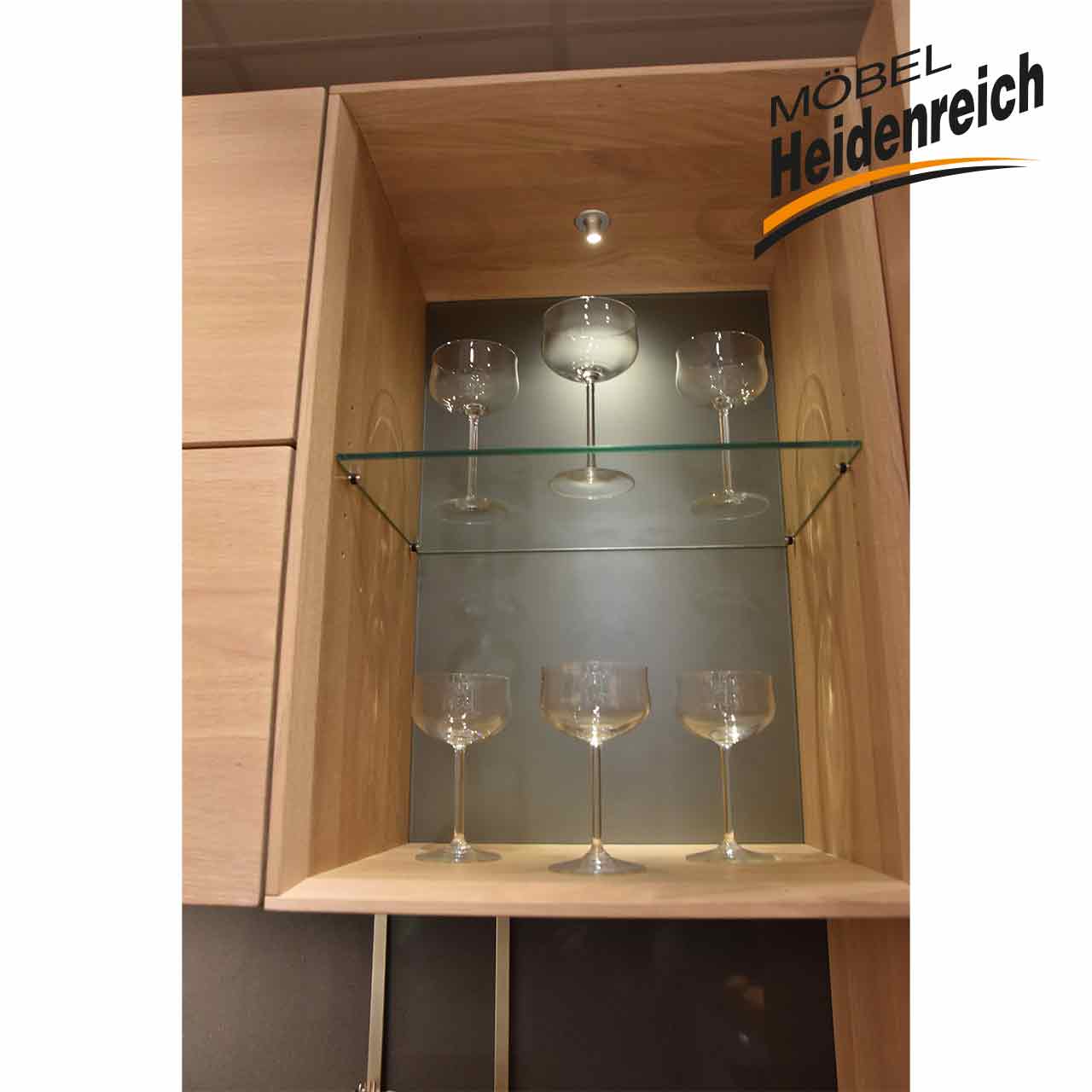 Offenes Fach mit Glasboden in der Mitte mit Gläsern als Dekoration.