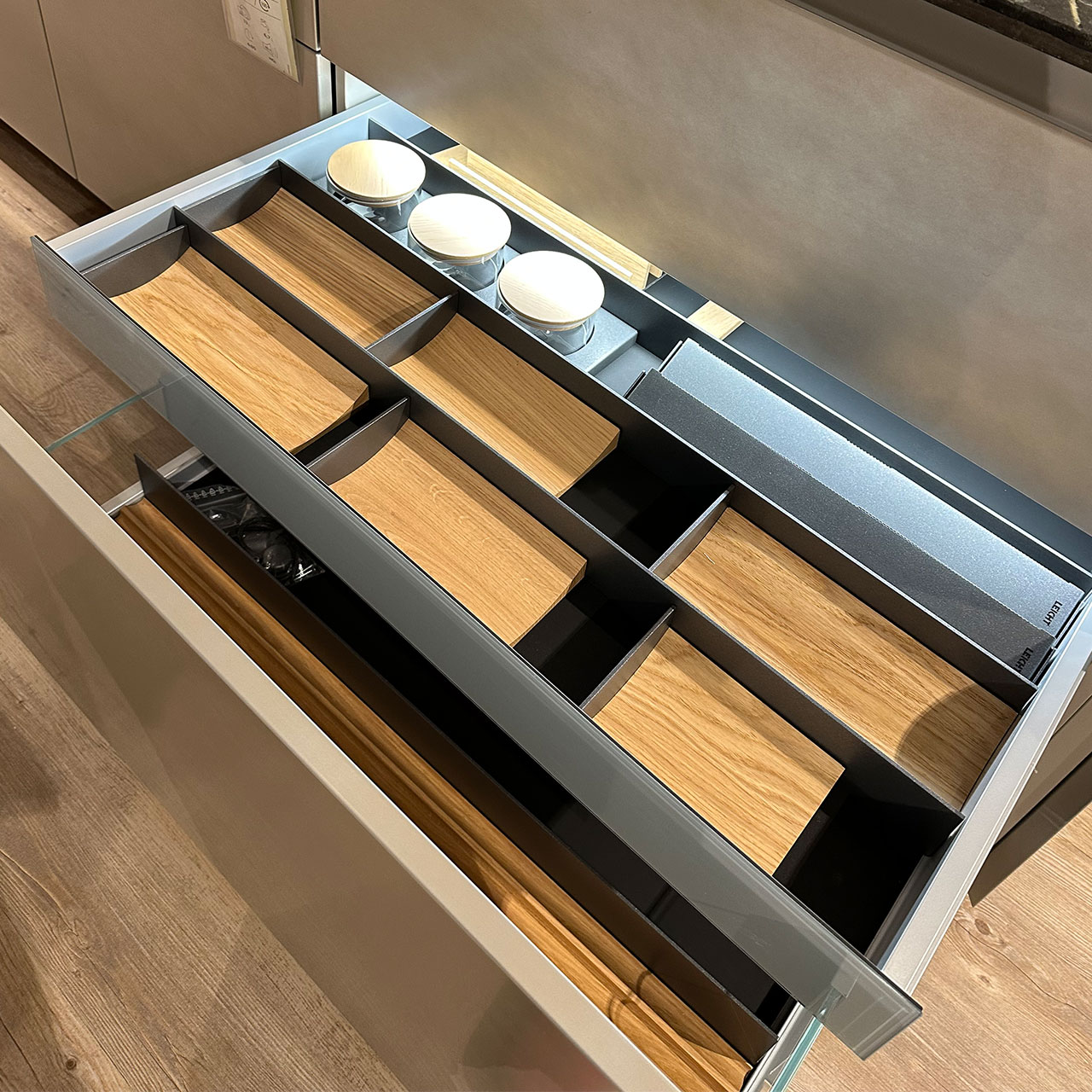 Blick in eine geöffnete Schublade, die praktische hochwertige Einsätze für Ordnung in der Küche enthält.