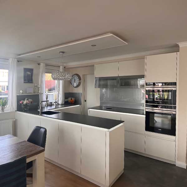 Küche Familie Jurczyk Weiße Küche mit schwarzer Arbeitsplatte grifflos.